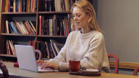 Attractive-woman-in-jumper-using-laptop