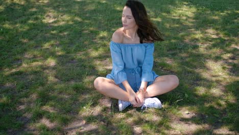 Retrato-De-Mujer-Morena-Atractiva-En-Vestido-Azul-Sentado-En-Un-Parque