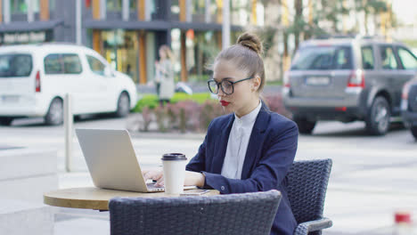 Businesswoman-with-laptop-in-outside-cafe