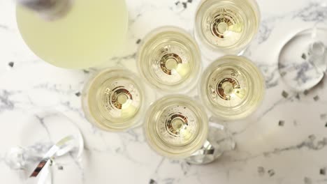 Champagne-glasses-and-bottle-placed-on-white-marble-background