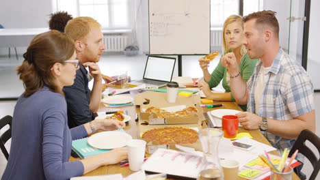 Young-people-enjoying-pizza-in-office