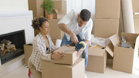 Young-couple-packing-boxes-to-move-home