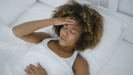 Young-woman-having-headache-lying-in-bed