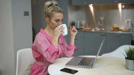 Woman-drinking-and-using-laptop