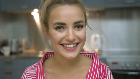 Cheerful-young-woman-in-kitchen