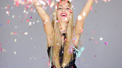 Sexy--blond-girl-blowing-confetti-to-camera-direction