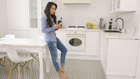 Joven-Mujer-Descalza-Usando-El-Teléfono-En-La-Cocina