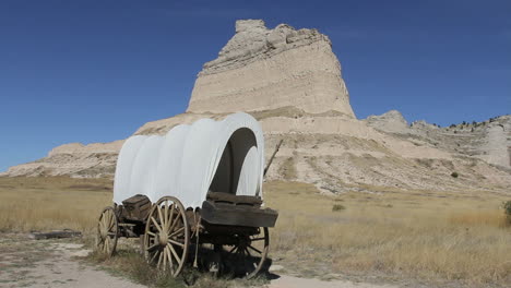 Nebraska-covered-wagon-in-front-of-erosion-remnant-at-Scotts-Bluff