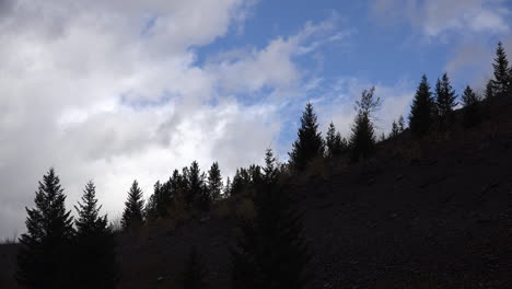 Montana-Nubes-Y-Cielo-Azul-Sobre-Pinos-Lapso-De-Tiempo