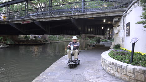 San-Antonio-man-rides-scooter-under-bridge-on-River-Walk