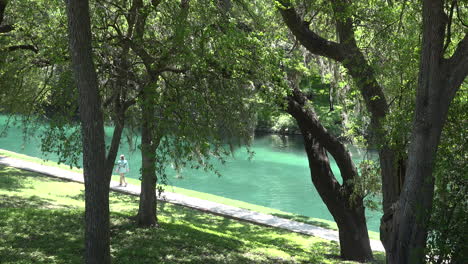 Texas-New-Braunfels-tourist-walks-by-Comal-River