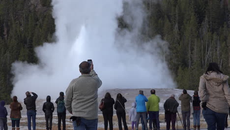 Yellowstone-man-approaches-Old-Faithful-eruption-with-camera-teléfono