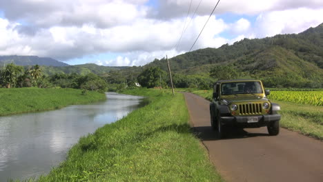 Kauai-A-jeep-on-a-road-by-a-stream