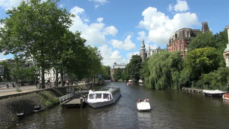 Netherlands-Amsterdam-small-boat-and-tour-boat-on-canal