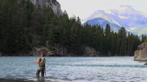 Canada-Alberta-Banff-Bow-River-fisherman-casting-and-mountain-3