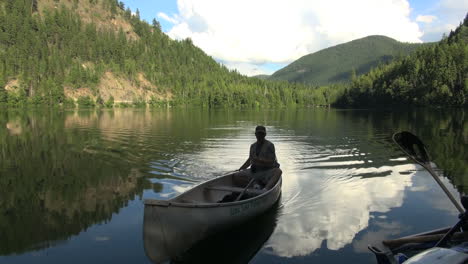 Canada-British-Columbia-Echo-Lake-canoe-on-water-reflecting-clouds
