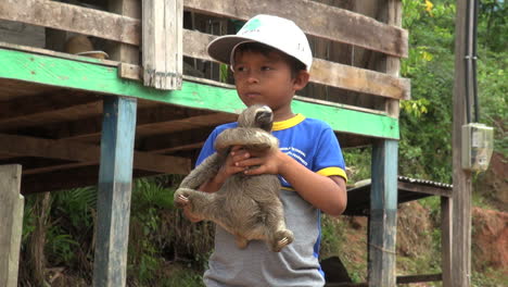 Brazil-Boca-da-Valeria-young-boy-holds-sloth