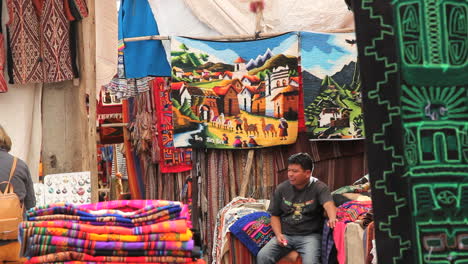 Peru-Pisac-market-man-eats-ice-cream-with-fabrics-all-around-6