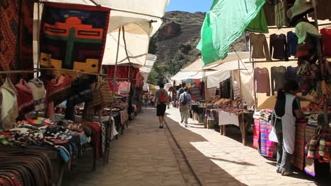 Peru-Pisac-market-shoppers-walk-past-goods-on-display-4