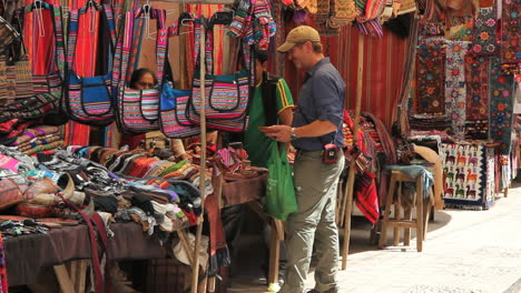 Peru-Pisac-market-man-barters-near-brightly-colored-bags-5