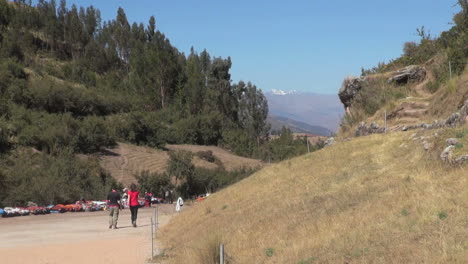 Peru-couple-walks-path-to-ruin-site