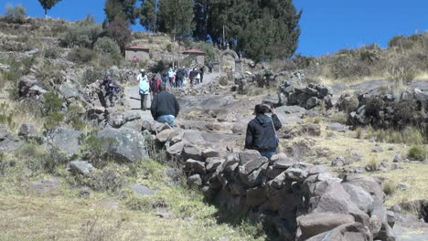 Peru-Taquile-climbing-hill-toward-arch-and-trees-26