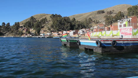 Peru-Lake-Titicaca-flags-and-dock-recede-as-boat-leaves