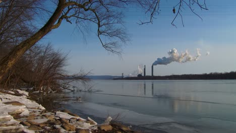 Smoke-rises-from-a-distant-power-plant-along-a-river-2