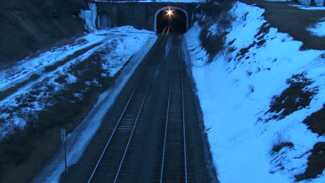 High-angle-over-a-freight-train-going-through-a-tunnel-at-night-in-the-winter