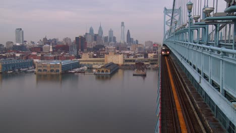 A-commuter-train-crosses-the-Ben-Franklin-Bridge-with-Philadelphia-PA-in-background