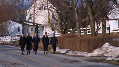Amish-girls-walk-along-a-road-in-rural-Pennsylvania
