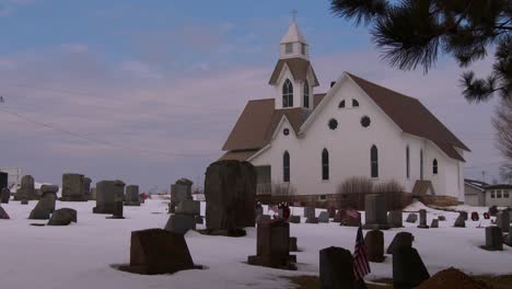 A-white-church-with-snow-and-graves-in-foreground