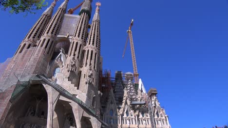 Low-angle-pan-across-the-Sagrada-Familia-cathedral-by-Gaudi-in-Barcelona-Spain