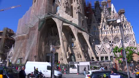 Traffic-passes-at-the-base-of-of-the-Sagrada-Familia-cathedral-by-Gaudi-in-Barcelona-Spain