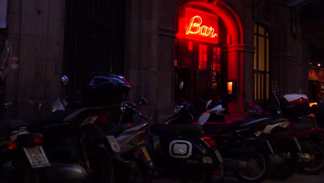 Klassische-Eröffnungsaufnahme-Einer-Bar-Mit-Neonreklame-Und-Motorrädern-Draußen