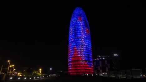 Remarkable-blue-and-red-skyscraper-at-night-in-Barcelona-Spain-1