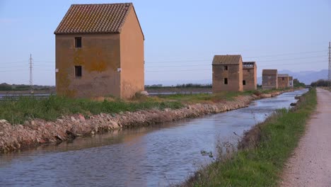 Unusual-square-adobe-huts-along-an-irrigation-canal-near-Albufera-Spain