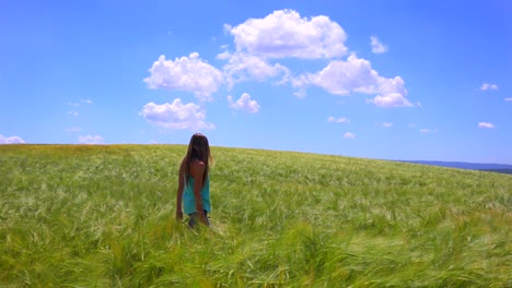 A-pretty-young-girl-walks-in-a-field-with-her-hair-blowing