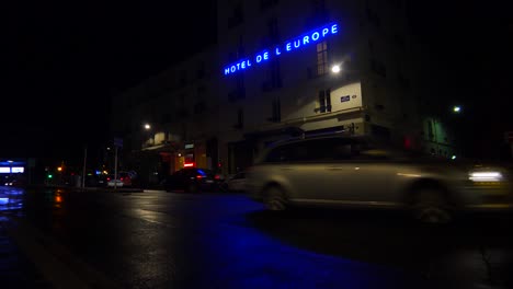 A-hotel-sign-is-reflected-in-rainy-streets-of-Paris-or-France-with-a-light-on-upstairs-2