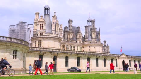 Bicyclists-ride-in-front-of-the-beautiful-chateau-of-Chambord-in-the-Loire-Valley-in-France