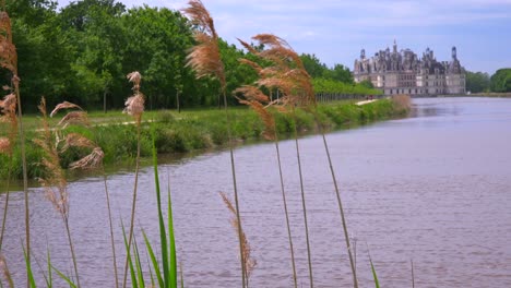 Long-view-down-a-canal-to-the-beautiful-chateau-of-Chambord-in-the-Loire-Valley-in-France-1