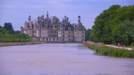 Long-view-down-a-canal-to-the-beautiful-chateau-of-Chambord-in-the-Loire-Valley-in-France-2