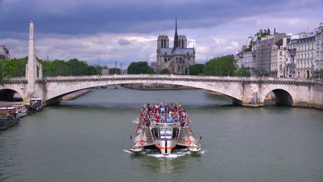 Ein-Flussschiff-Fährt-Unter-Brücken-In-Der-Nähe-Der-Kathedrale-Notre-Dame-In-Paris-2