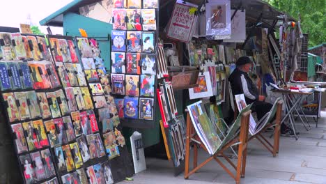 Ein-Straßenhändler-In-Paris-Verkauft-Zeitschriften-Und-Kunstwerke