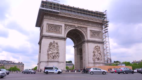 An-ambulance-or-emergency-vehicle-circles-around-the-Arc-De-Triomphe-in-París-France