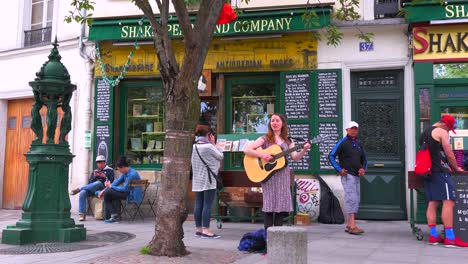 Ein-Mädchen-Spielt-Volksmusik-Vor-Einer-Buchhandlung-Und-Einem-Café-In-Paris