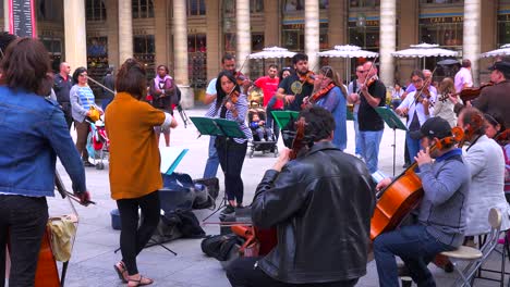 A-symphony-orchestra-in-street-clothes-plays-music-on-the-streets-of-París-1