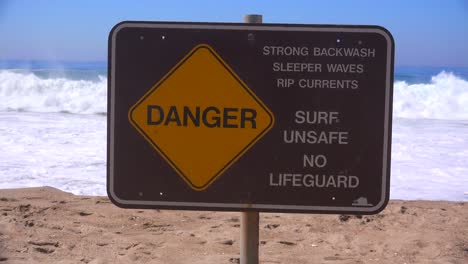 A-sign-along-a-California-beach-warns-of-dangerous-surf-and-strong-rip-currents-1