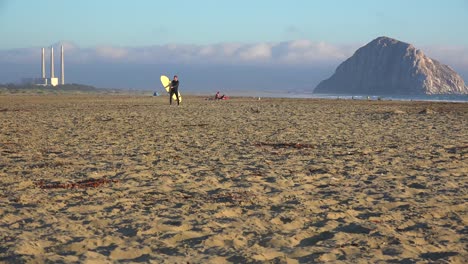 Ein-Surfer-Kreuzt-Vor-Dem-Wunderschönen-Morro-Bay-Rock-Entlang-Der-Zentralen-Küste-Kaliforniens-1