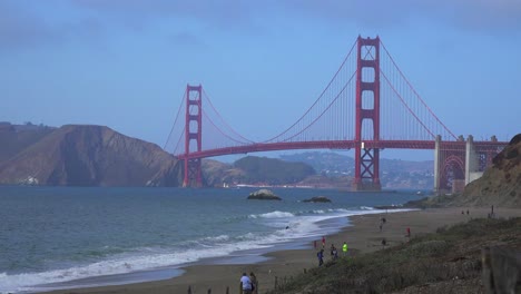 A-view-across-Baker-Beach-in-San-Francisco-to-the-Golden-Gate-Bridge-with-waves-crashing-on-shore-1